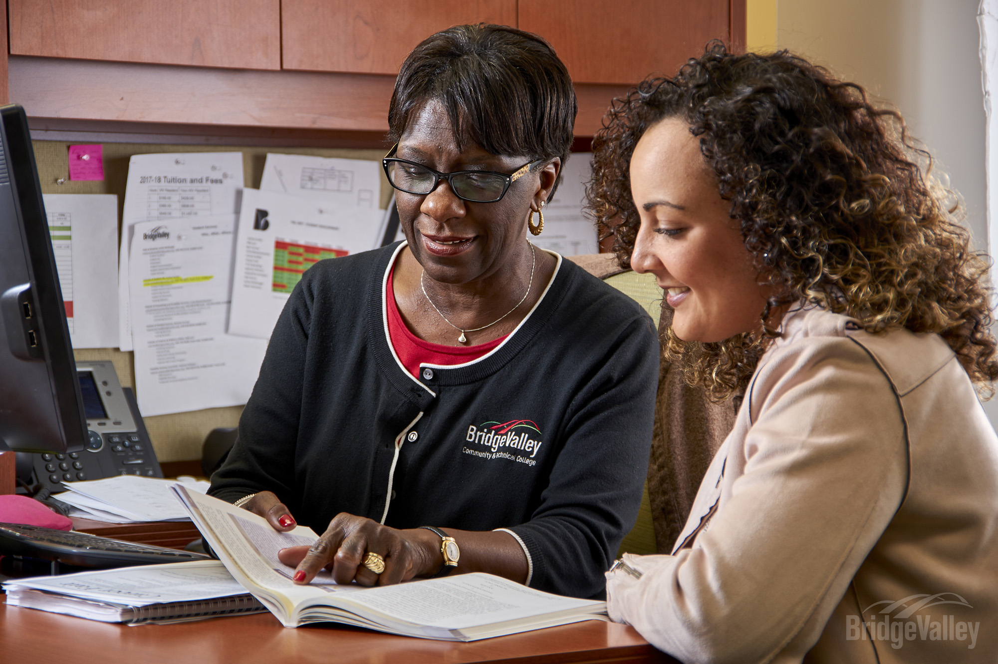 Student sitting with teacher.