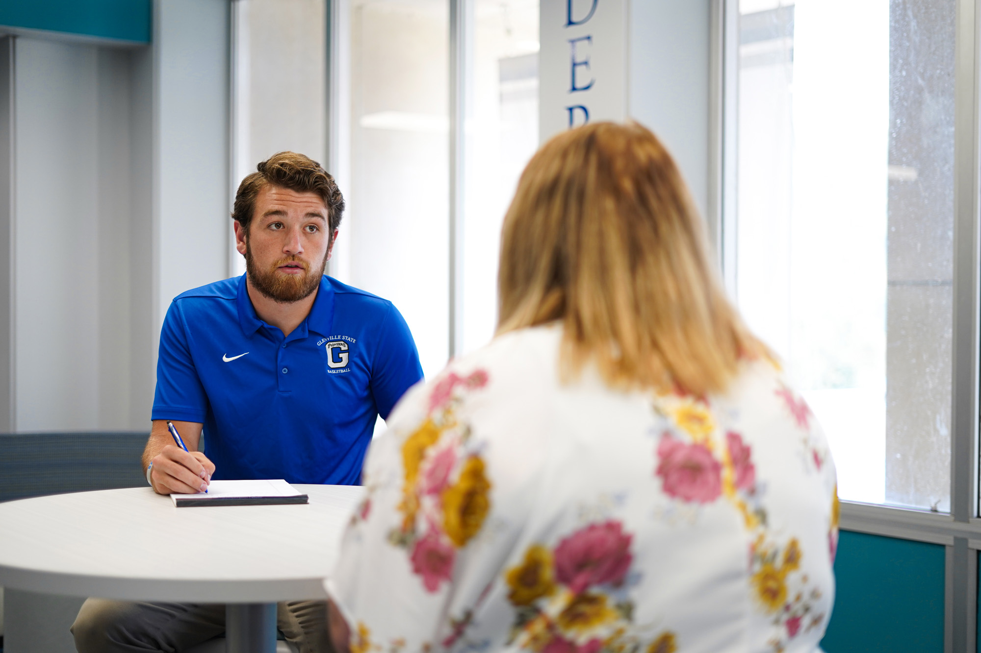 Student sitting with counselor.